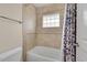 Well-lit bathroom featuring tiled shower and glass block window offering natural light and privacy at 24965 E Roxbury Pl, Aurora, CO 80016