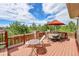 A view of the deck from the corner showcases outdoor furniture, railing, and beautiful surrounding greenery at 24965 E Roxbury Pl, Aurora, CO 80016