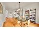 Bright dining room featuring hardwood floors, glass table, modern chandelier, and shelving at 24965 E Roxbury Pl, Aurora, CO 80016