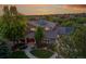 Stunning two-story home with professional landscaping and solar panels against a colorful twilight sky at 24965 E Roxbury Pl, Aurora, CO 80016
