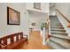 Bright foyer featuring hardwood floors, staircase, and view into the dining and living areas at 24965 E Roxbury Pl, Aurora, CO 80016