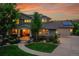 Charming home featuring a covered porch, well-manicured lawn, mature trees, and solar panels above the garage at 24965 E Roxbury Pl, Aurora, CO 80016