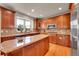 Bright kitchen with wood cabinets, stainless appliances, and an island with bar seating at 24965 E Roxbury Pl, Aurora, CO 80016