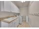 Laundry room with white cabinets, utility sink, washer and dryer at 24965 E Roxbury Pl, Aurora, CO 80016