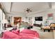Open living room with tray ceiling, neutral tones, comfortable seating, and a view into the kitchen at 24965 E Roxbury Pl, Aurora, CO 80016
