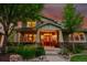 Inviting covered porch with stone accents, comfortable seating, and a welcoming entryway enhanced by warm lighting at 24965 E Roxbury Pl, Aurora, CO 80016