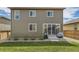 The home's back exterior with sliding glass doors, small patio and lush green yard at 25621 E Cedar Pl, Aurora, CO 80018