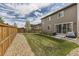 A spacious backyard with green lawn, wood fence, gravel, and patio, perfect for outdoor enjoyment at 25621 E Cedar Pl, Aurora, CO 80018