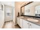 Bright bathroom with double sinks, a large mirror, and a glass-enclosed shower at 25621 E Cedar Pl, Aurora, CO 80018