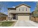 Charming two-story home featuring stone accents, a two-car garage, and a well-manicured front yard with an American flag at 25621 E Cedar Pl, Aurora, CO 80018