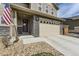 Close-up of a home's exterior showing the stone-accented facade, a two-car garage, and an inviting front entry at 25621 E Cedar Pl, Aurora, CO 80018