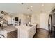 Open-concept kitchen with white cabinetry, a large island, and dark wood floors leading to a cozy living area at 25621 E Cedar Pl, Aurora, CO 80018