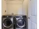 Laundry room featuring side-by-side washer and dryer units with a white door at 25621 E Cedar Pl, Aurora, CO 80018