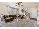 Cozy living room with a comfortable brown sofa, a ceiling fan, and a staircase leading to the upper level at 25621 E Cedar Pl, Aurora, CO 80018