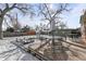 Back deck with outdoor seating, surrounded by a snowy backyard and mature trees at 950 Laurel St, Broomfield, CO 80020