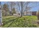 Backyard with mature trees, deck, and shed offers a private oasis for outdoor activities and relaxation at 5485 E Bails Dr, Denver, CO 80222
