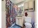 Bathroom featuring a colorful shower curtain, vanity with storage, and neutral-toned walls at 5485 E Bails Dr, Denver, CO 80222
