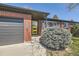 Brick home featuring attached garage and stylish yellow front door at 5485 E Bails Dr, Denver, CO 80222
