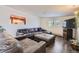 Inviting living room with a large sectional, dark wood floors, and a pass-through to the kitchen at 5485 E Bails Dr, Denver, CO 80222