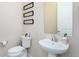 Well lit half bathroom with pedestal sink and modern accents at 6657 S Kline Way, Littleton, CO 80127