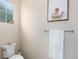 Cozy bathroom featuring toilet, towel rack, decorative picture, and a bright window at 6657 S Kline Way, Littleton, CO 80127