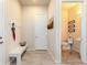 Inviting entryway with a coat rack, white bench and half bathroom at 6657 S Kline Way, Littleton, CO 80127