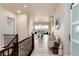 Bright hallway featuring hardwood floors, staircase and an open layout leading into the dining area at 6657 S Kline Way, Littleton, CO 80127