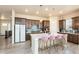 Well-lit kitchen featuring an oversized island with barstool seating and stainless steel appliances at 6657 S Kline Way, Littleton, CO 80127