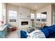 Comfortable living room featuring a stone fireplace, large windows, stylish seating and decor at 6657 S Kline Way, Littleton, CO 80127