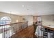 Upstairs hallway with wood floors, iron railings, and natural light at 16921 W 60Th Dr, Arvada, CO 80403