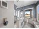 Contemporary bathroom with shower, bath, and abundant sunlight illuminating the stylish gray interior at 5602 Silver Bluff Ct, Parker, CO 80134