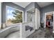 Elegant bathroom featuring a walk-in shower, large window, and sleek gray tile at 5602 Silver Bluff Ct, Parker, CO 80134
