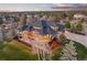A beautiful home boasts an expansive deck overlooking mature trees and lush lawns with an open view of the landscape at 5602 Silver Bluff Ct, Parker, CO 80134