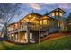 Stylish two-story home featuring a stone facade, lighted deck, and lush landscaping at 5602 Silver Bluff Ct, Parker, CO 80134