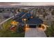 Exterior elevation of a home with a three-car garage, dark roof, and deck overlooking open spaces at 5602 Silver Bluff Ct, Parker, CO 80134