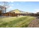 A serene backyard featuring lush green grass, a fire pit, and a privacy fence at 12715 E 104Th Pl, Commerce City, CO 80022