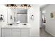 Bright bathroom featuring double sink vanity with framed mirror and modern lighting fixtures at 12715 E 104Th Pl, Commerce City, CO 80022