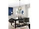 Contemporary dining area with stylish chairs, decor, lighting fixture flowing to living room with blue accent wall at 12715 E 104Th Pl, Commerce City, CO 80022