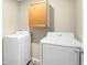 Bright laundry room featuring modern, front loading, white washer and dryer at 12715 E 104Th Pl, Commerce City, CO 80022