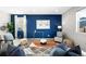 Bright living room with modern decor, a bold blue accent wall, and comfortable seating at 12715 E 104Th Pl, Commerce City, CO 80022