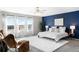 Beautiful main bedroom with a large window, seating, and a vibrant accent wall at 12715 E 104Th Pl, Commerce City, CO 80022