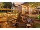 Charming backyard with a fire pit surrounded by wicker chairs and ambient string lights for outdoor relaxation at 16158 Whitestone Dr, Parker, CO 80134