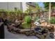 Landscaped backyard pond with lush greenery, rock features, and decorative statues at 16158 Whitestone Dr, Parker, CO 80134