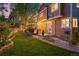 Well-manicured backyard with flagstone patio, green lawn, and a lighted deck for relaxing outdoor evenings at 16158 Whitestone Dr, Parker, CO 80134