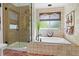 Bright bathroom featuring a glass-enclosed shower, soaking tub, and neutral tile work at 16158 Whitestone Dr, Parker, CO 80134