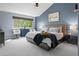 Well-lit bedroom with blue walls, large windows, plush carpeting, and comfortable bed at 16158 Whitestone Dr, Parker, CO 80134