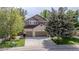 Charming two-story home with a brick facade, mature trees, and a well-manicured lawn at 16158 Whitestone Dr, Parker, CO 80134