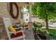Inviting front porch with rocking chairs, seasonal wreath, and colorful cushions adds cozy charm to the home at 16158 Whitestone Dr, Parker, CO 80134