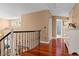 Bright hallway with gleaming hardwood floors, an ornate iron railing, and tan painted walls at 16158 Whitestone Dr, Parker, CO 80134