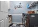 Well-organized laundry room with checkered floors, front-loading washer and dryer, and white storage shelving at 16158 Whitestone Dr, Parker, CO 80134